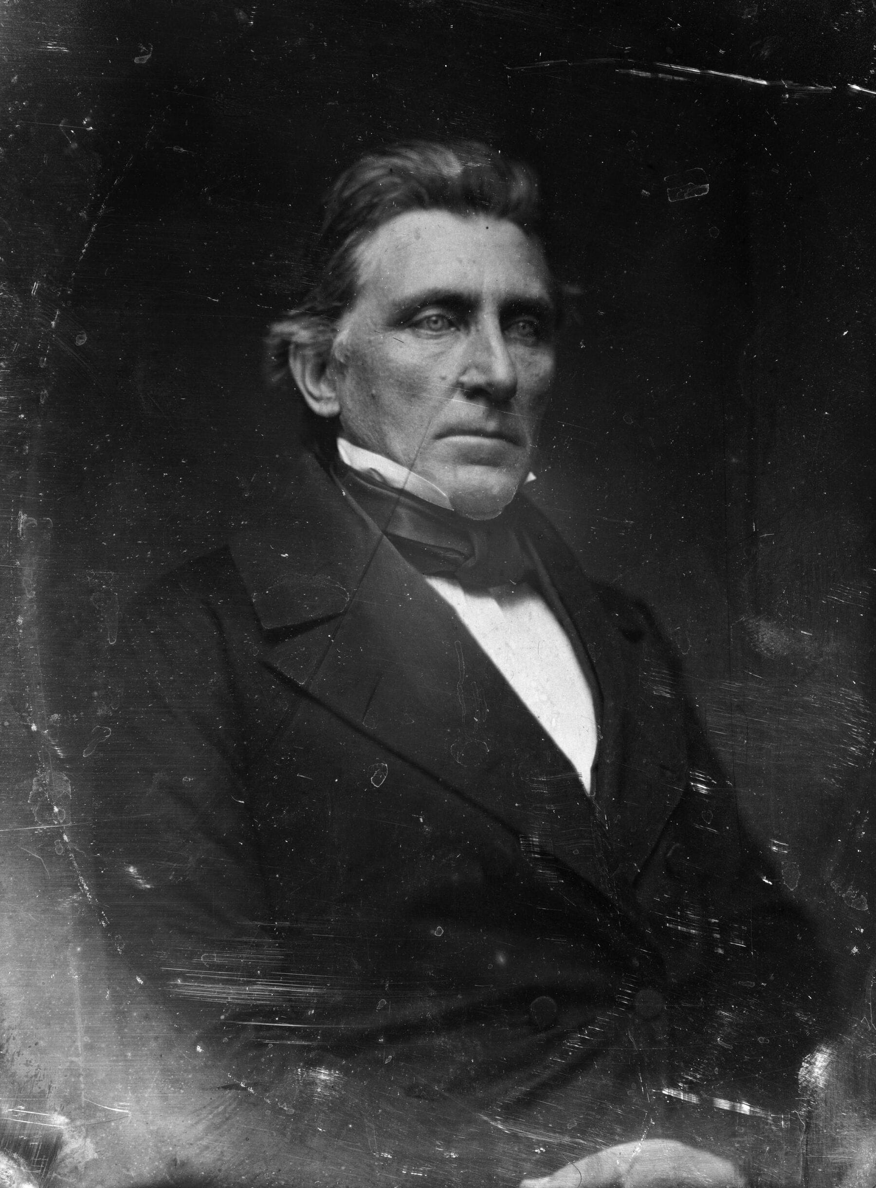 Daguerrotype silvered at edges of finely dressed stern looking man with pale, cruel eyes