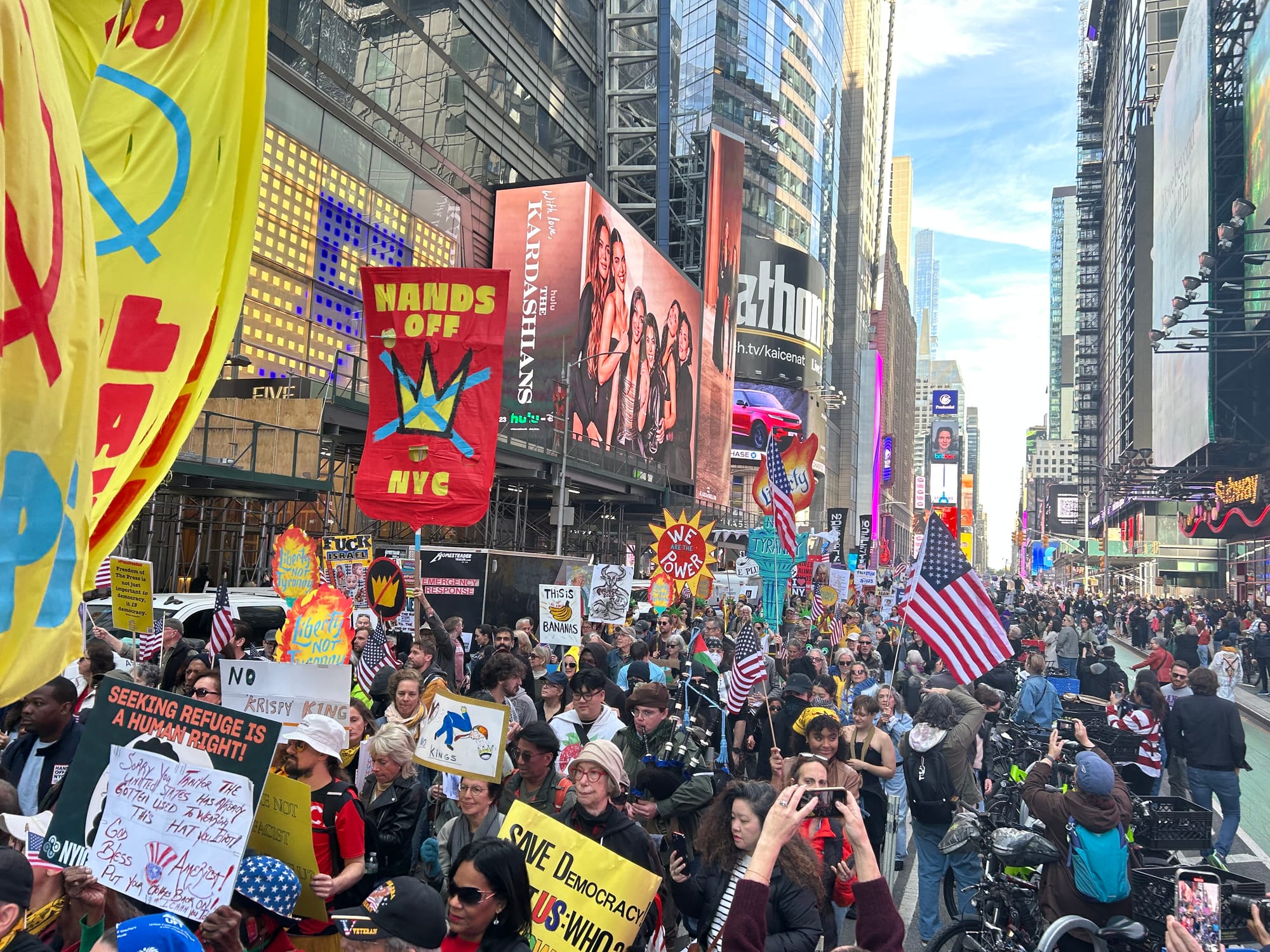 Phenomenal brilliantly colorful image of thousands of protesters in NYC with HANDS OFF NYC, SAVE Democracy and American flags visible