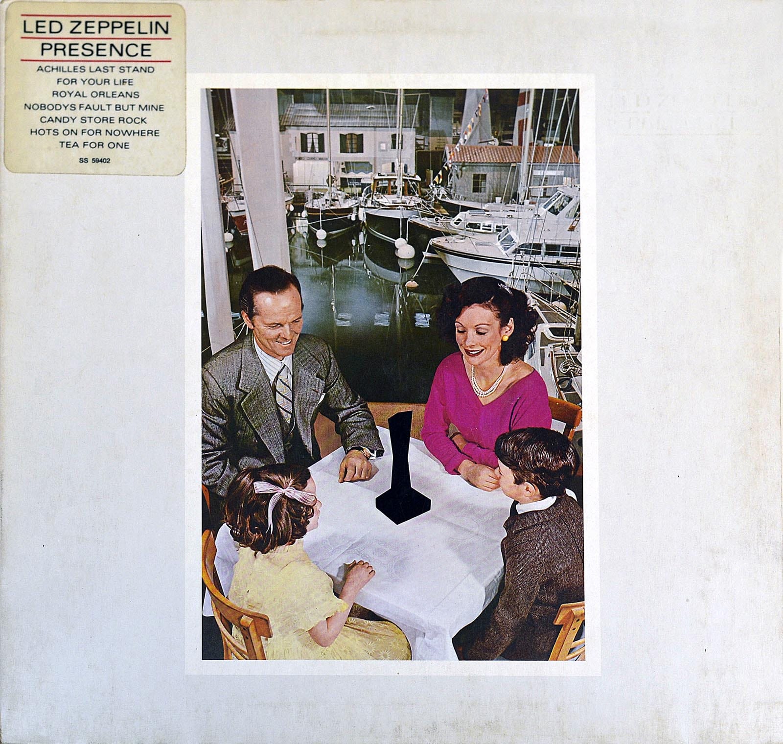 Cover of Led Zeppelin 'Presence' (1976) depicting a famiy at table before a jet-black Object