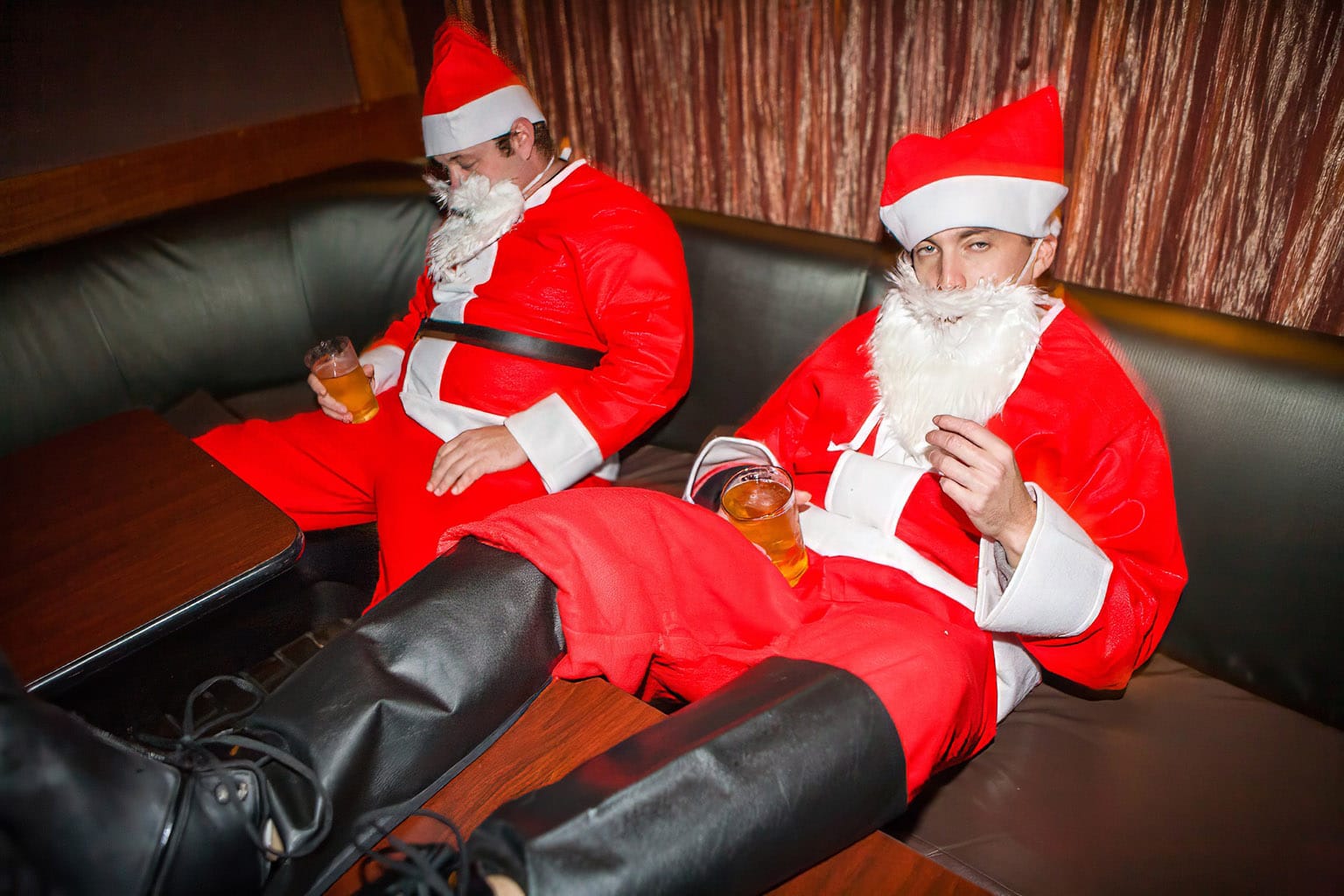 Groggy Santas in a lounge barely holding their mixed drinks upright.
