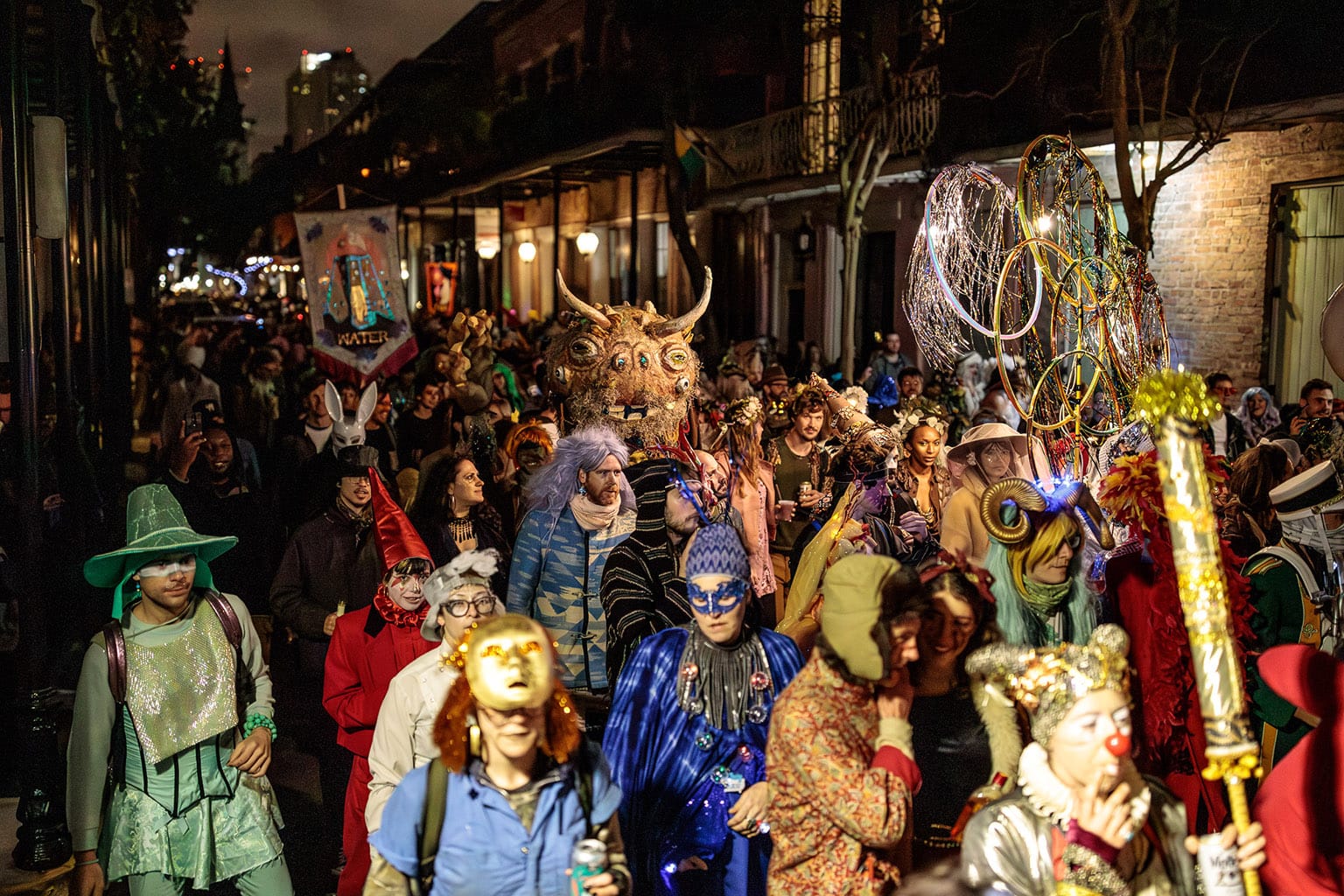 The colorfully costumed crowd throngs the streets in a nighttime parade