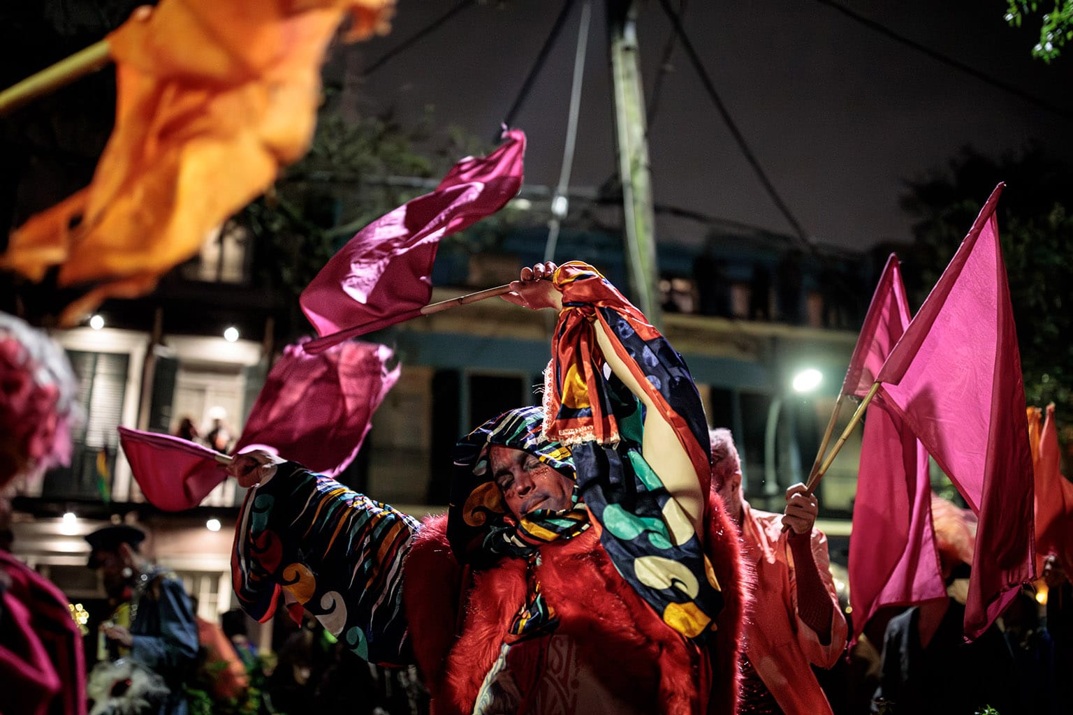 Transported, a gaily costumed Eris parader waves a purple banner