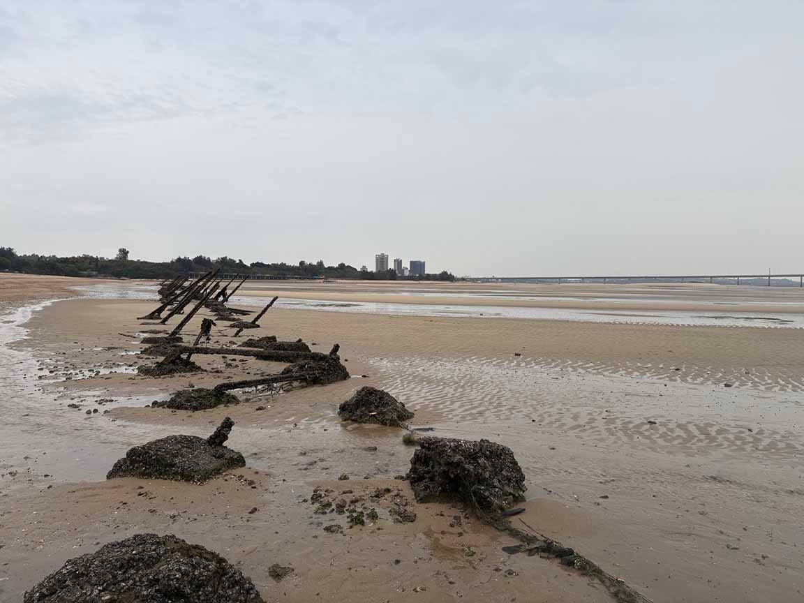 Huge rusted metal spikes on a long, flat beach