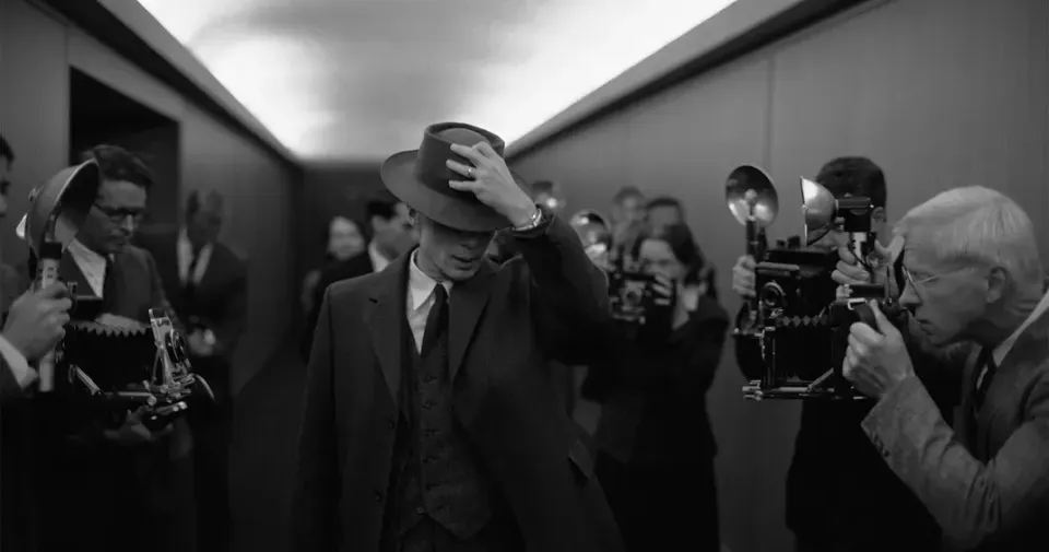 Cillian Murphy as Robert Oppenheimer, walking reluctantly through a phalanx of photographers 