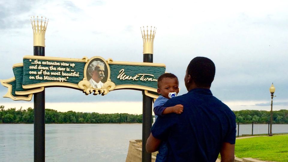 The author and his baby son in Hannibal, Missouri, standing before a large sign depicting Mark Twain