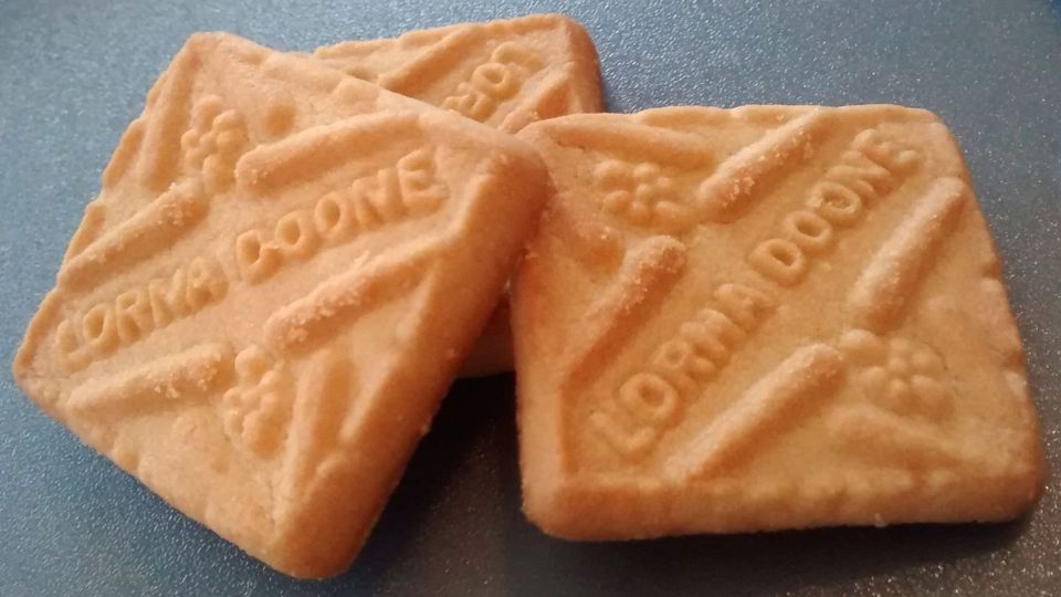 Three Lorna Doone shortbread cookies, quite appetizing looking, golden and crumbly, on a grey formica counter