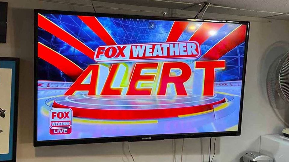 TV SCREEN: FOX WEATHER ALERT FOX WEATHER LIVE, glowing red and yellow with red rays emanating pure panic