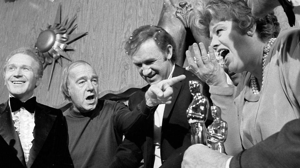 Gene Hackman (center) in a black and white publicity photo on Oscar night, 1972, on the set of The Poseidon Adventure