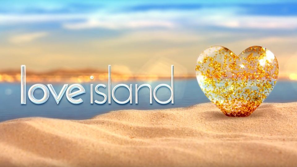 Opening credits of 'Love Island' feature a transparent heart filled with gold glitter perched in sand the color of pale toast