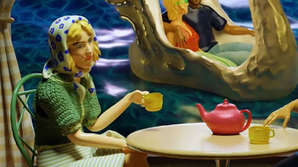 A Barbie-like plastic figure of a woman drinking tea; she wears a blank, doll-like expression