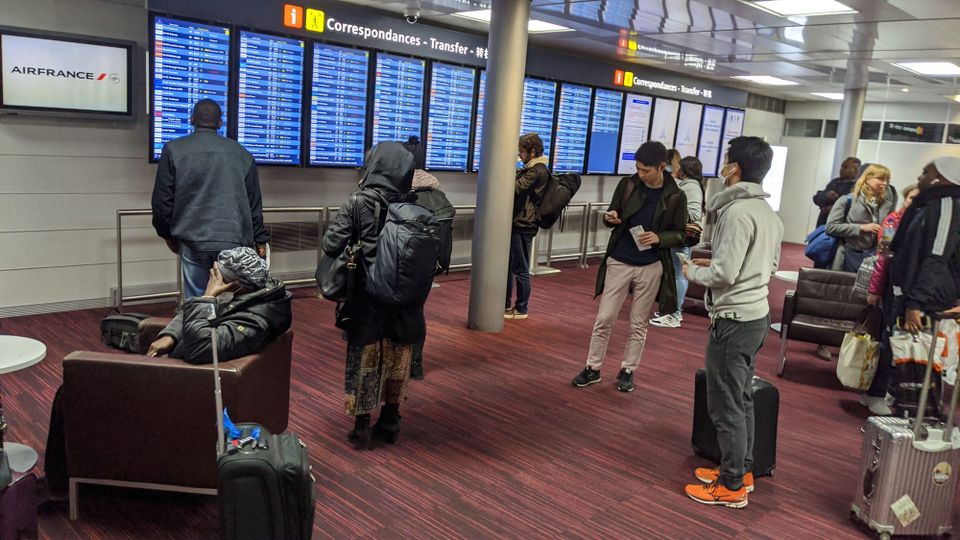Heathrow Airport scene during the pandemic in 2020, with hopeful passengers checking flight board