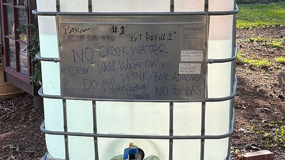 A huge plastic container of well water in Asheville, North Carolina, with cautions to use for washing, not to drink