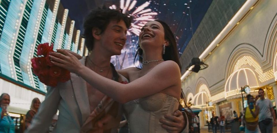 Movie still, low, wide angle of happy romantic couple on Fremont in Vegas