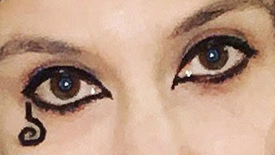 Black-lined eyes, character-accurate black goth curly upside-down question-mark symbol under corner of eye.