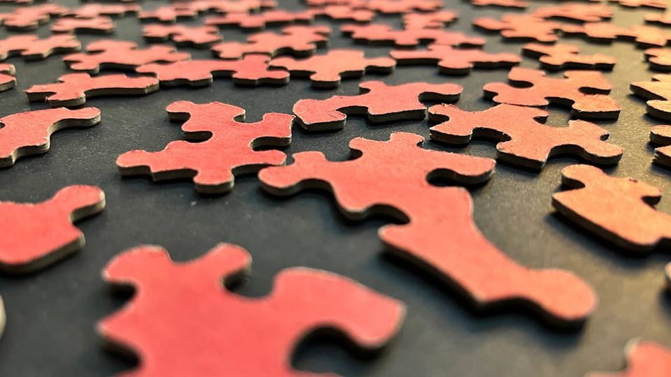 Red puzzle pieces stretch back to the horizon