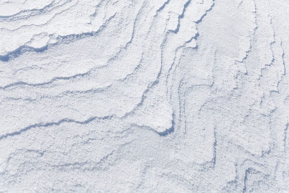 Photo: texture of flat drifting snow with curved shadows