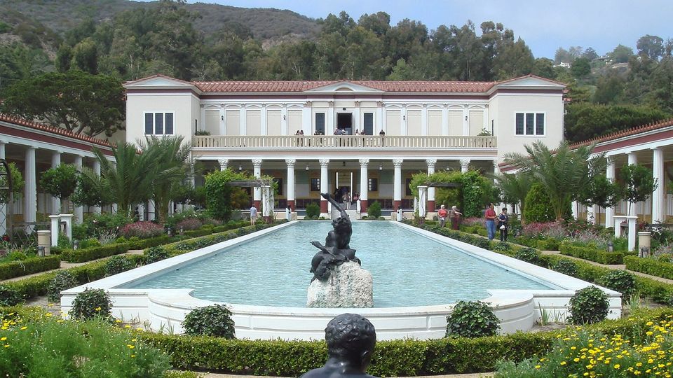 The Getty Villa, courtyard and pool surrounded by a formal garden planted with lush palms, hedges, flowers