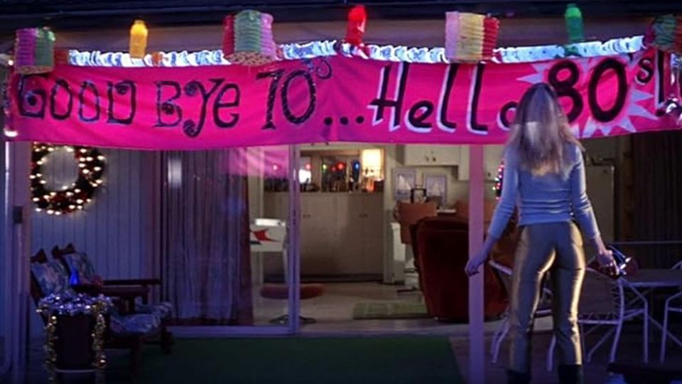 Heather Graham rolls up to the New Year's Eve party where a huge pink banner reads, 'Good Bye 70's...Hello 80's'