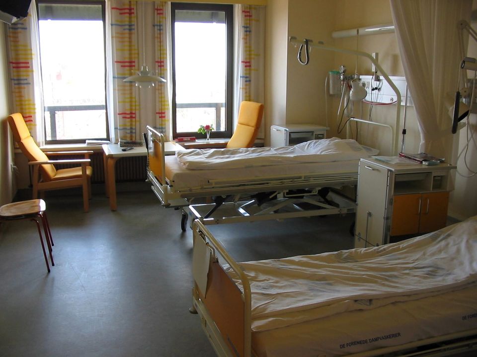 A hospital room with two empty beds