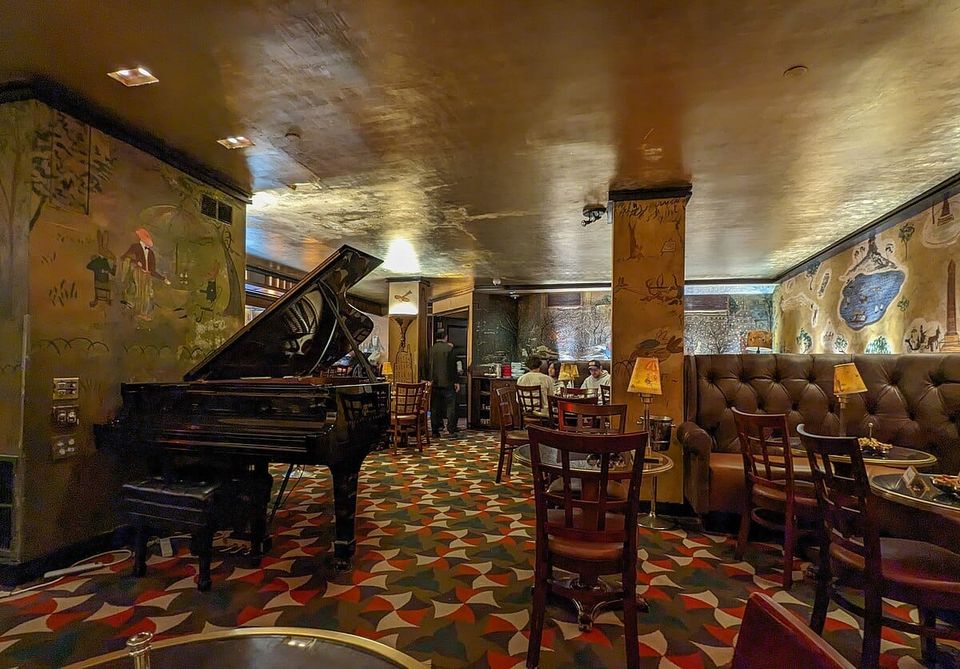 Interior, Bemelmans Bar, Hotel Carlyle, New York City; a sumptuously furnished cocktail bar with gold leaf ceiling, famous murals and a piano