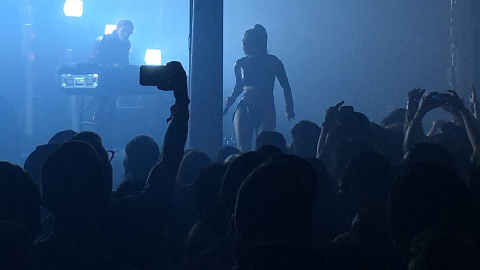 Charli xcx onstage, viewed from crowd, performing with SOPHIE at SXSW in March 2016