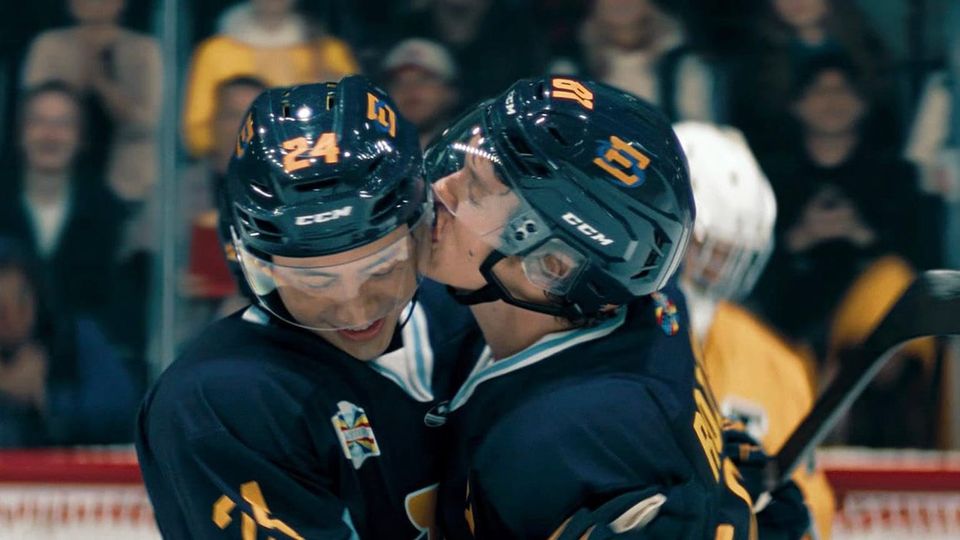 Hockey players on ice embracing joyfull