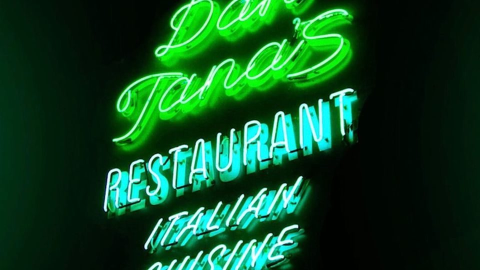 Green and light blue neon in the dark: DAN TANA’S RESTAURANT ITALIAN CUISINE