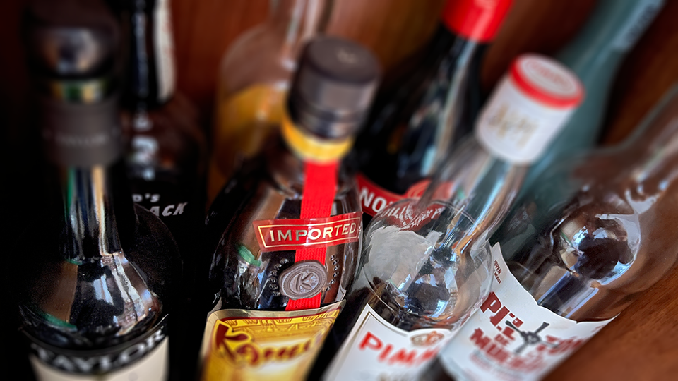 A fuzzy photo of bottles in a liquor cabinet