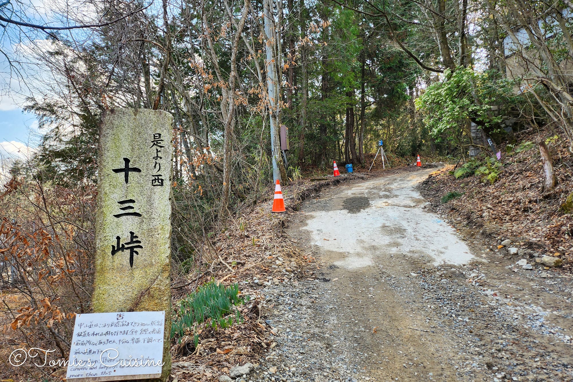 Jusan Toge mountain pass stone sign with a handwritten caution board about there being no shops or accommodations until Mitake post town.