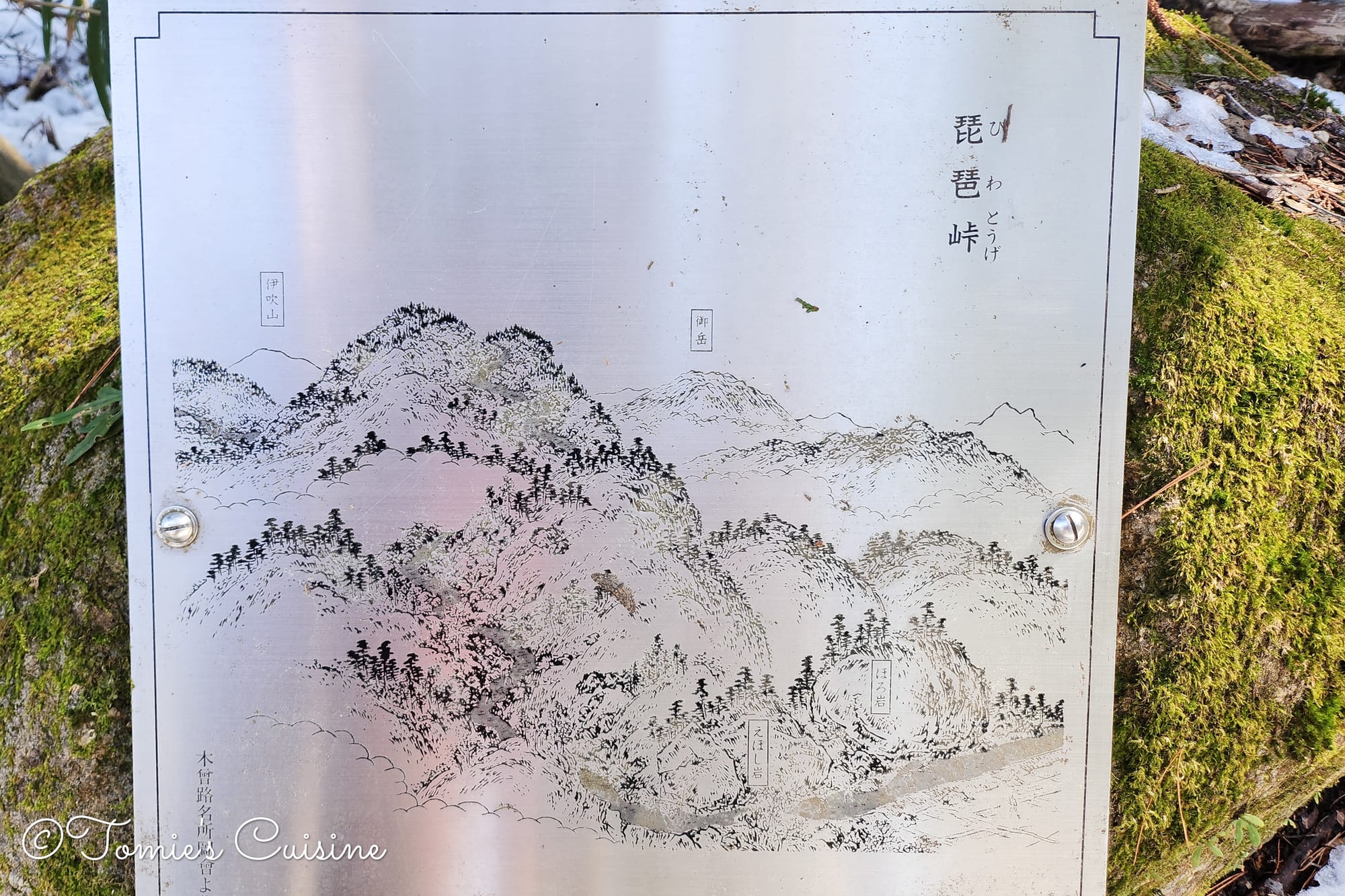 Historical drawing of Biwa Mountain Pass on the metal board on the rock.