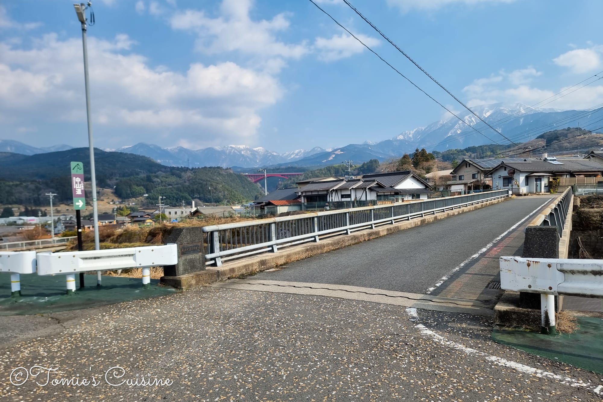 Bridge over the bypass at Ochiai with snowy mountains behind