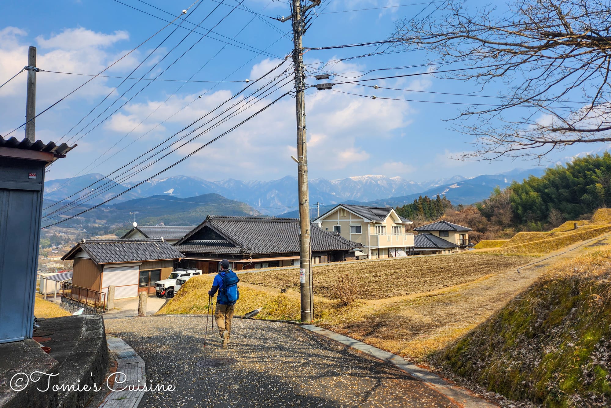 Kevin walking down the Nakasendo slope at Yosaka with mountains ahead