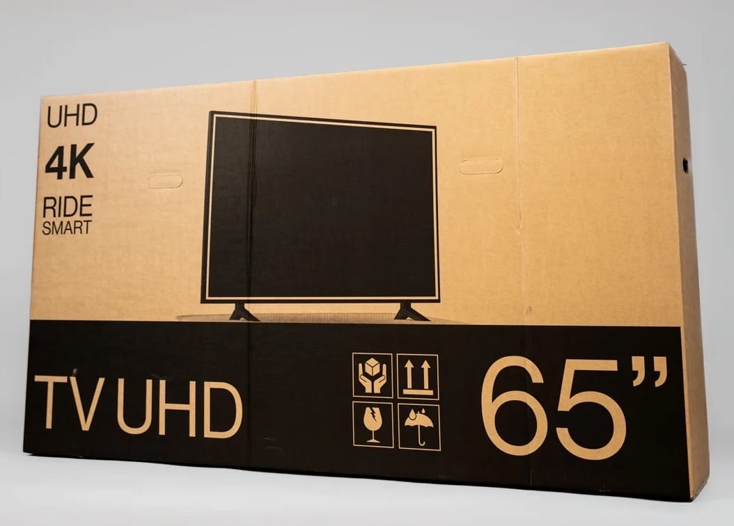 A sealed buycycle bike shipping box printed to look like a 65-inch UHD TV box
