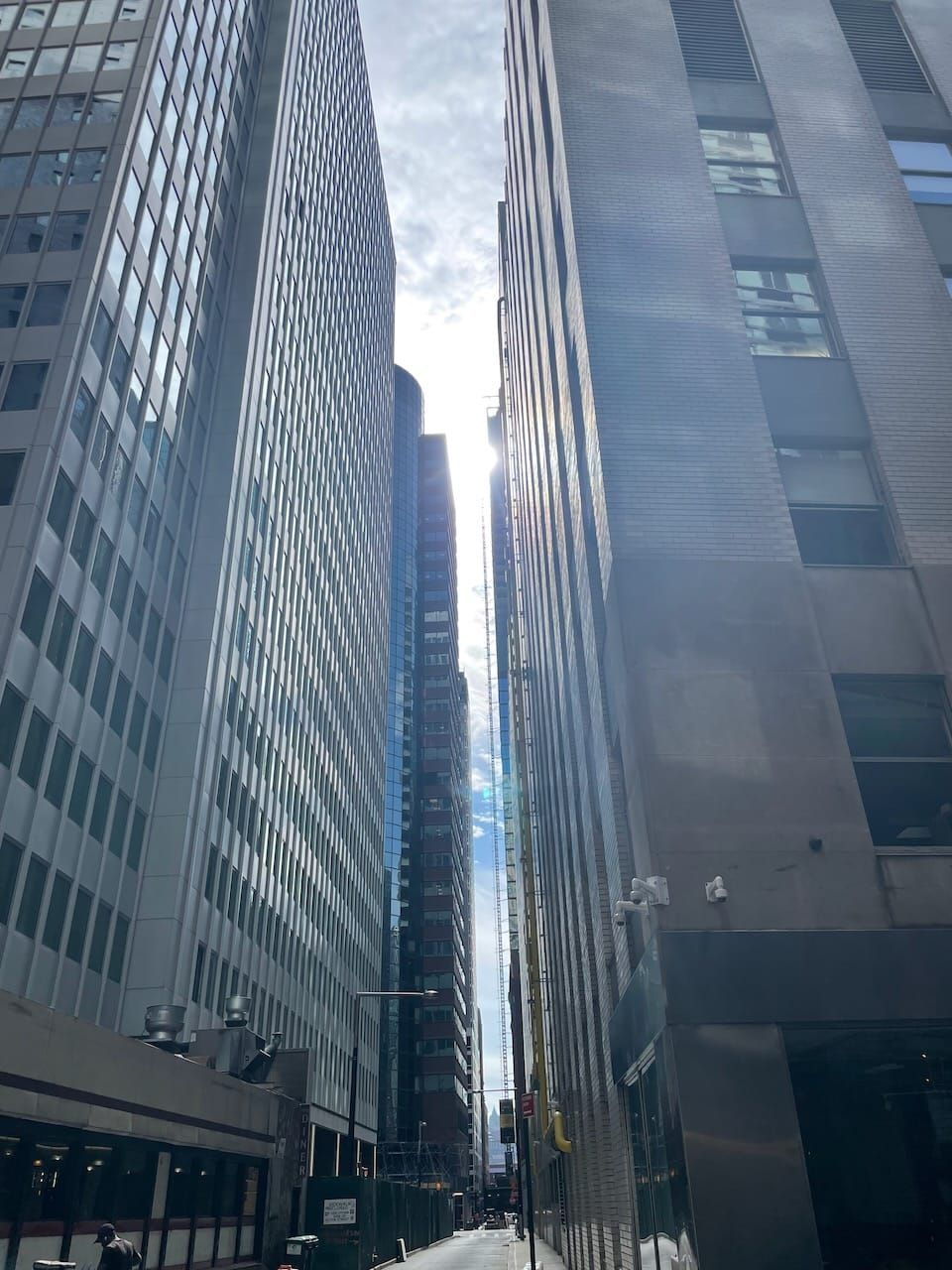 Sun shining through buildings in a New York City skyline.