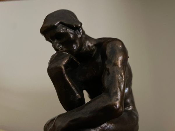 A small bronze facsimile of Rodin's "Thinker".  