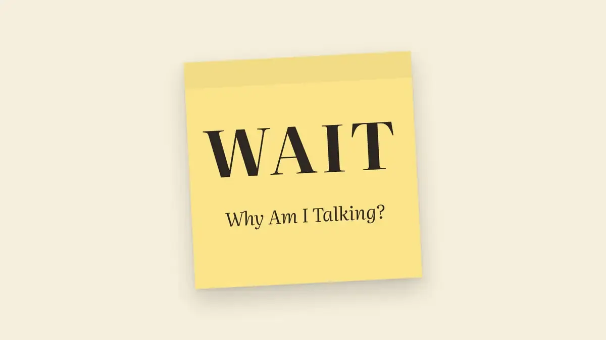 A yellow Post-it note reading WAIT – Why Am I Talking?