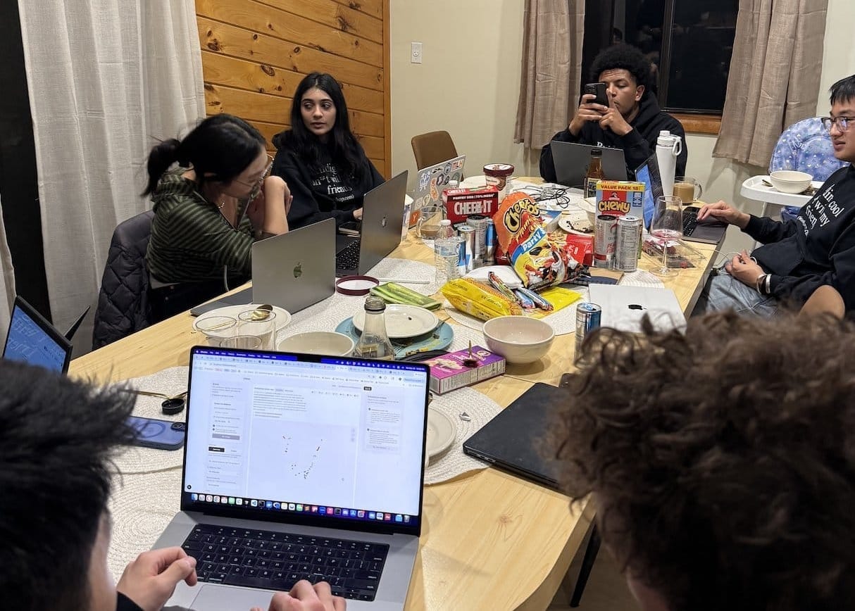 students working on laptop around table
