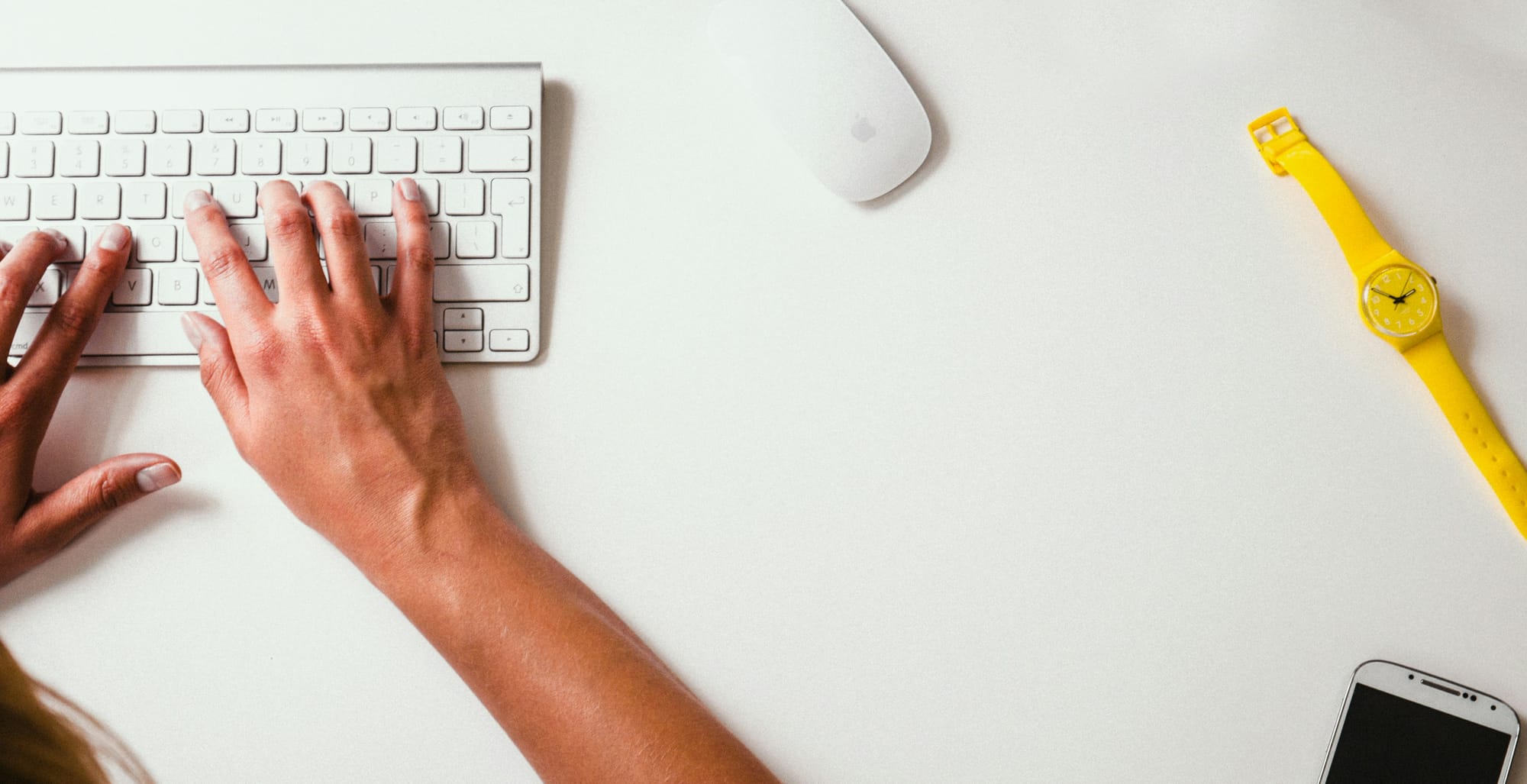 Picture of a woman typing on a keyboard at a desk