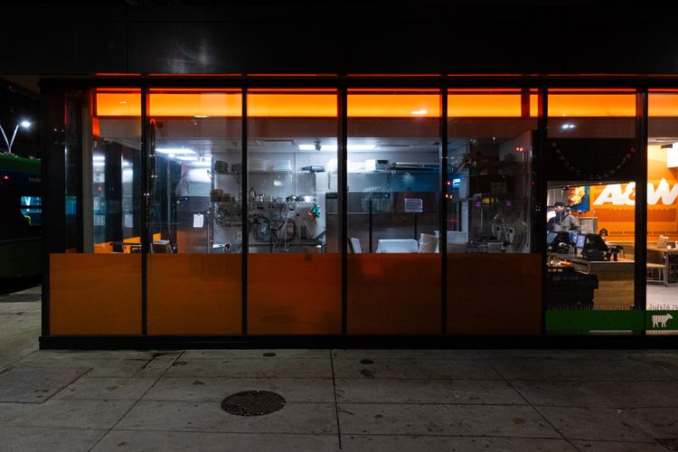 Picture of an A&W restaurant located under the SkyTrain tracks, night