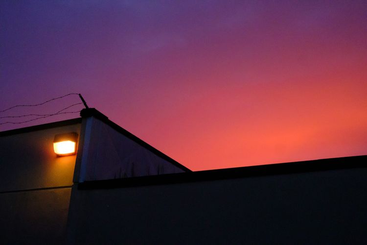 Sunset and light rain over a corner of a building; Collingwood, Vancouver