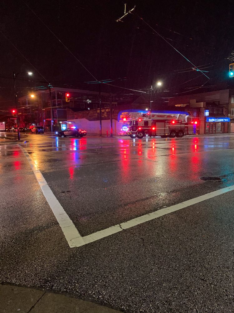 Emergency vehicles after an intersection crash in the early morning in rain; Kingsway, Vancouver