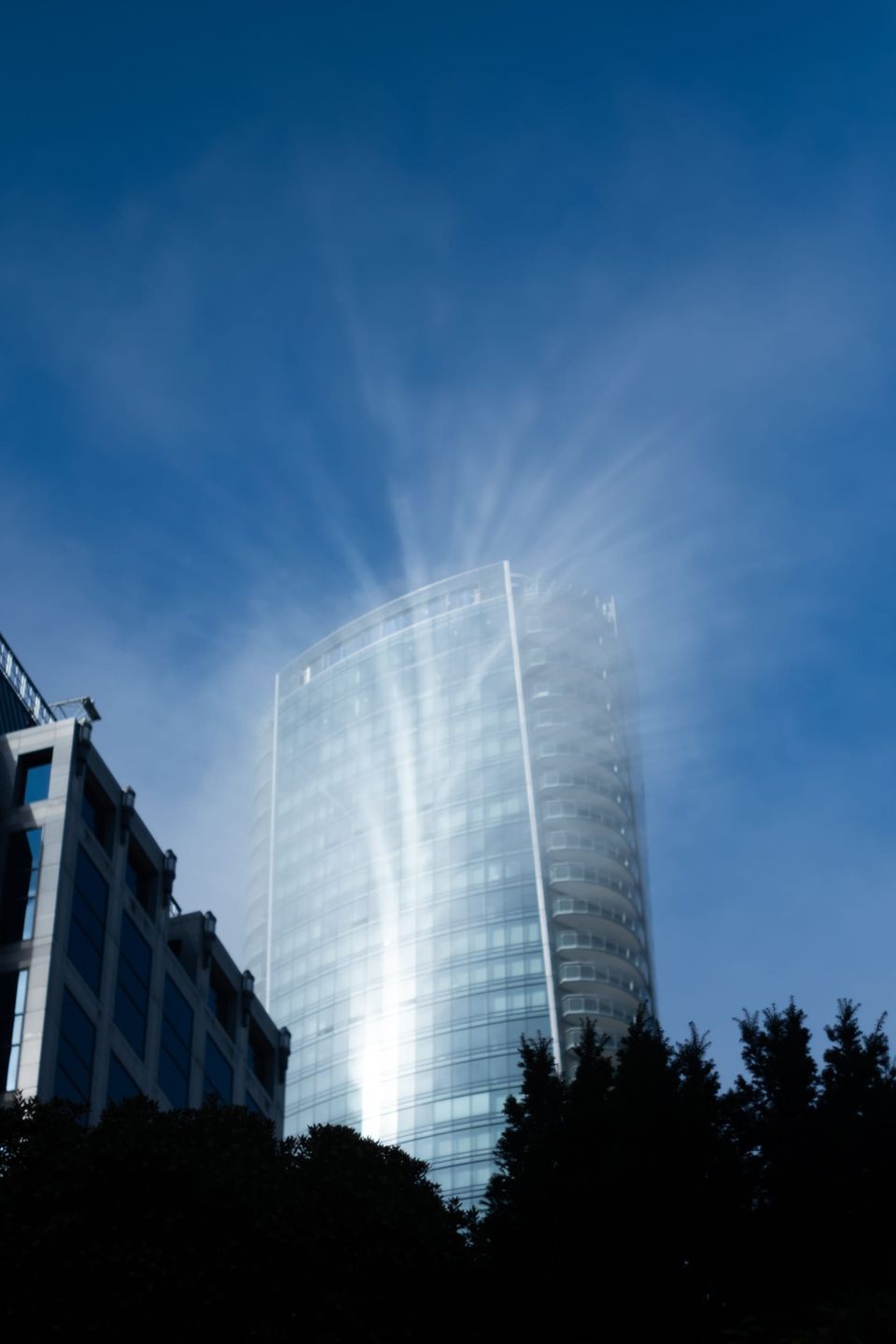 Clouds swirl from a tower façade as I come up from the train platform.
