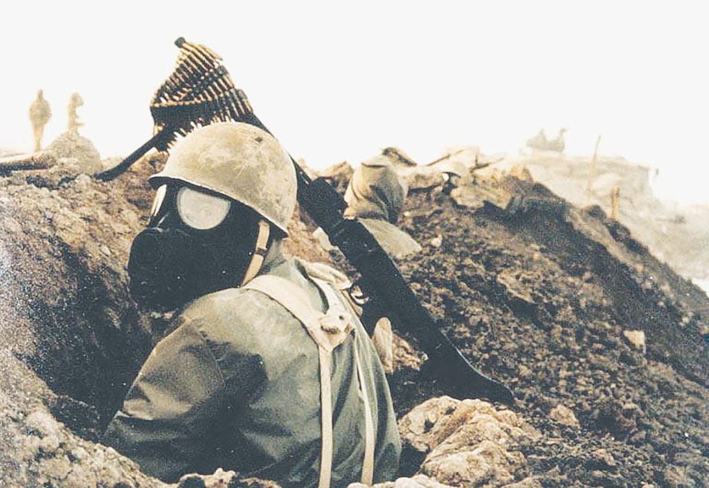 An Iranian soldier wearing a gas mask and M1 helmet during the Iran-Iraq War.
