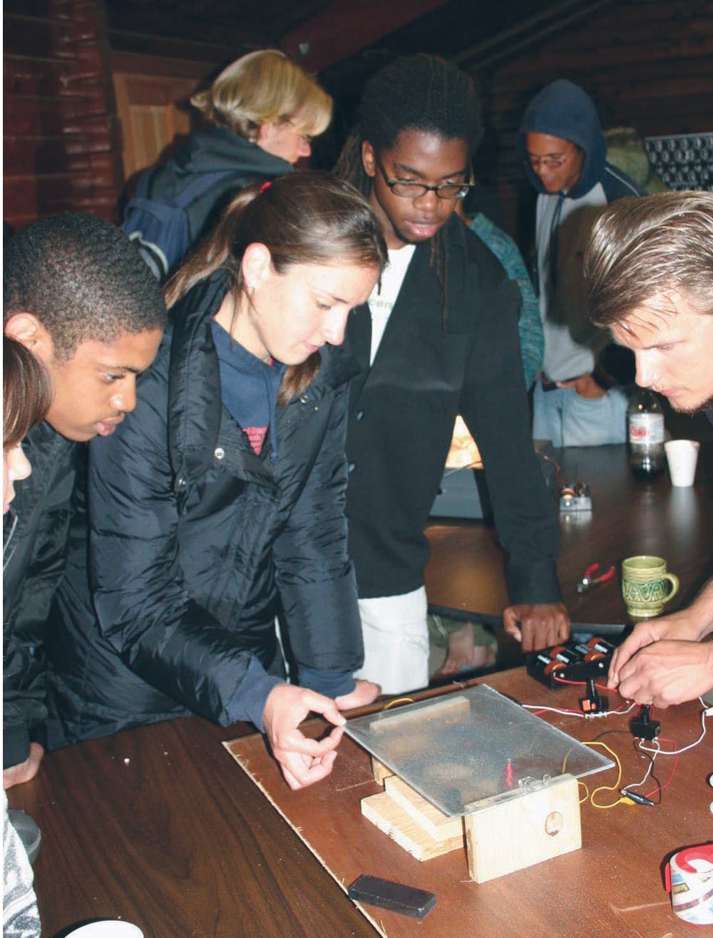Members of the LaRouche Youth Movement examine an electromagnetic apparatus