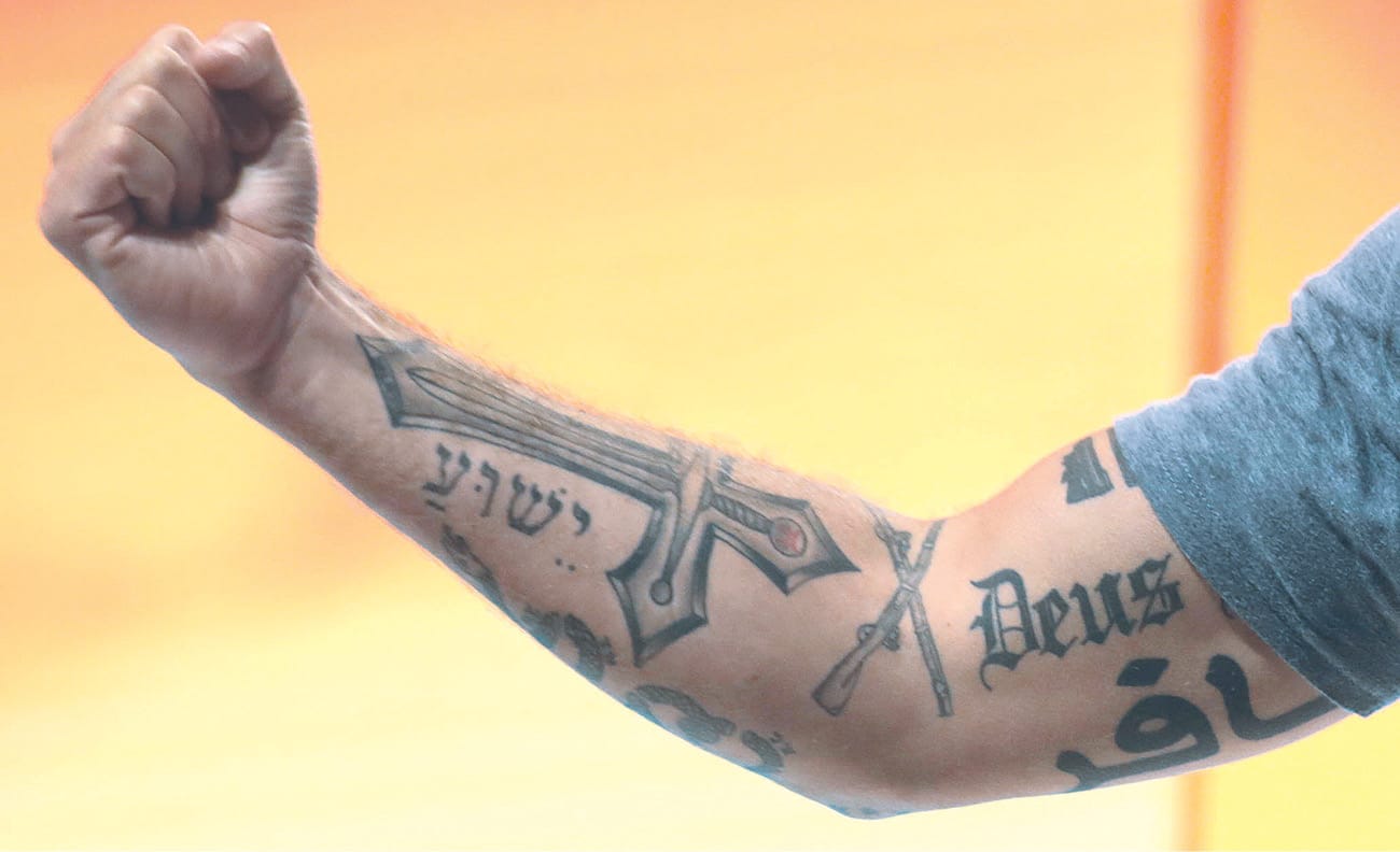 “Christian”-themed tattoos on the arm of “U.S. Secretary of War” Pete Hegseth.