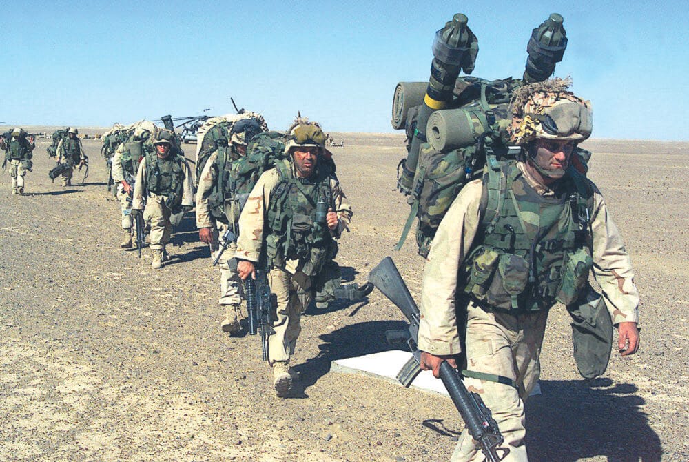Despite LaRouche’s admonition not to go into Afghanistan, an invasion was launched by the United States on Oct. 7, 2001, under the name Operation Enduring Freedom, resulting in a 20-year quagmire costing the lives of 2,459 U.S. military personnel and 176,000 Afghans. Shown here, U.S. Marines after seizing a Taliban forward-operating base, Nov. 25, 2001.