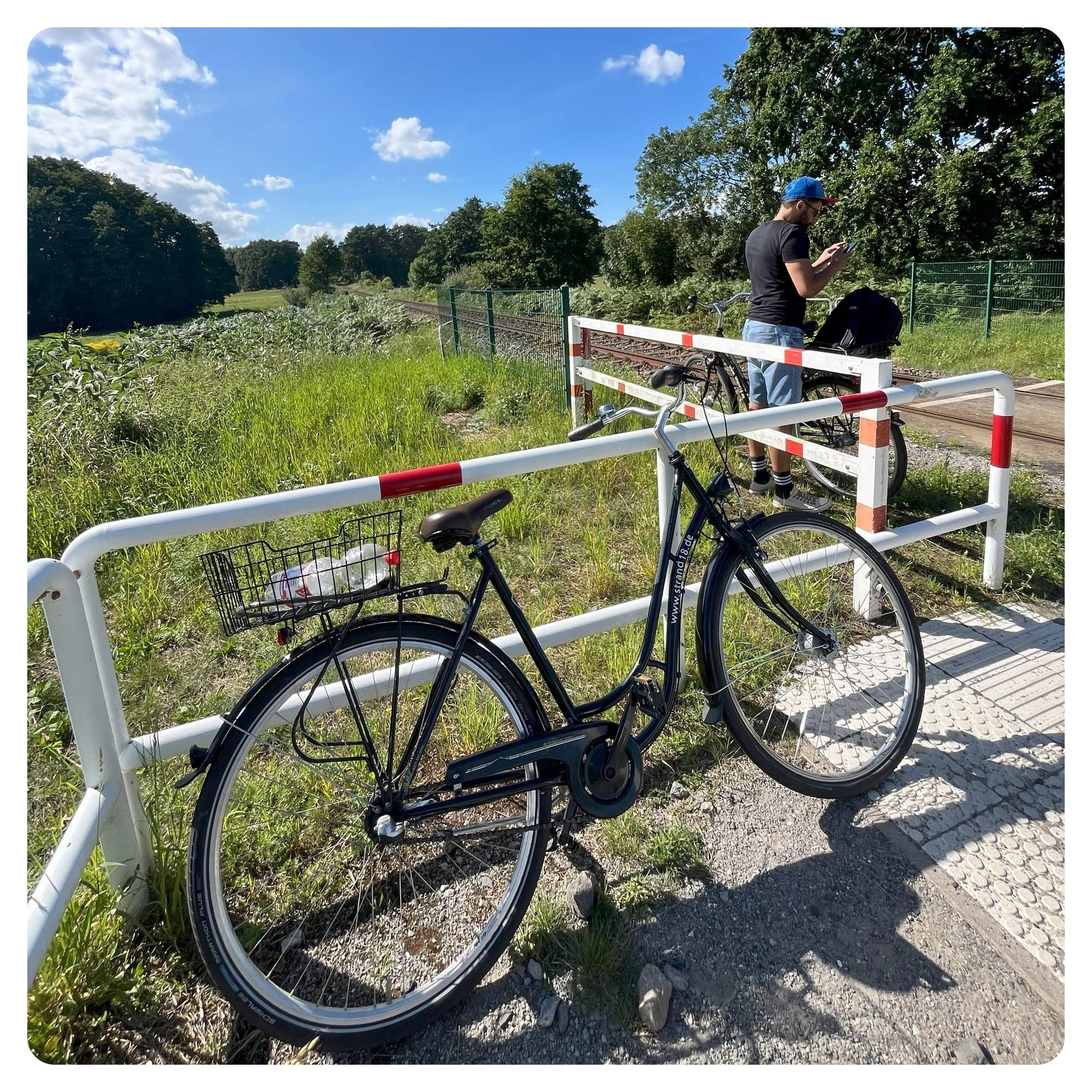 Black bicycle resting next to railway crossing in Zempin