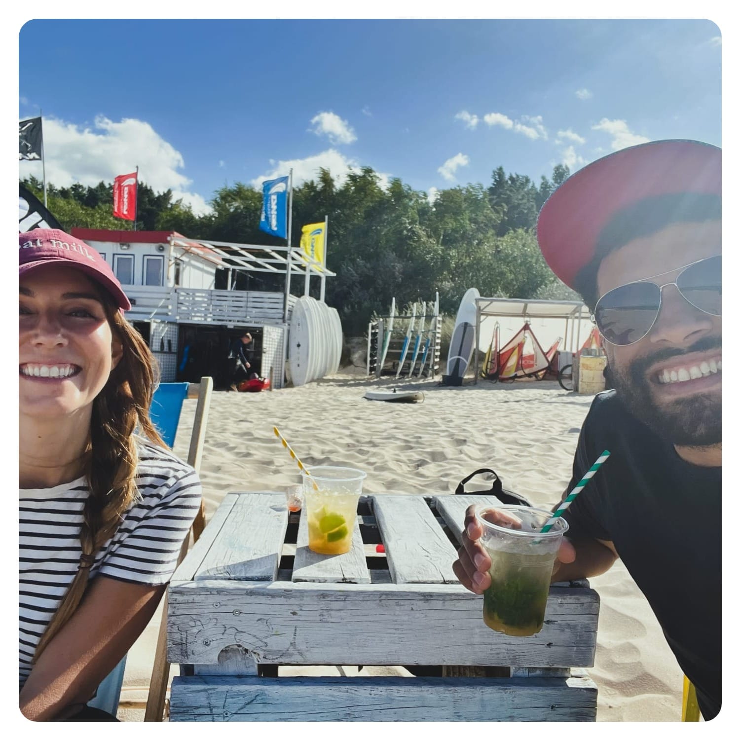 vanlavita woman and man enjoying cocktails on sunny white sand beach in Usedom