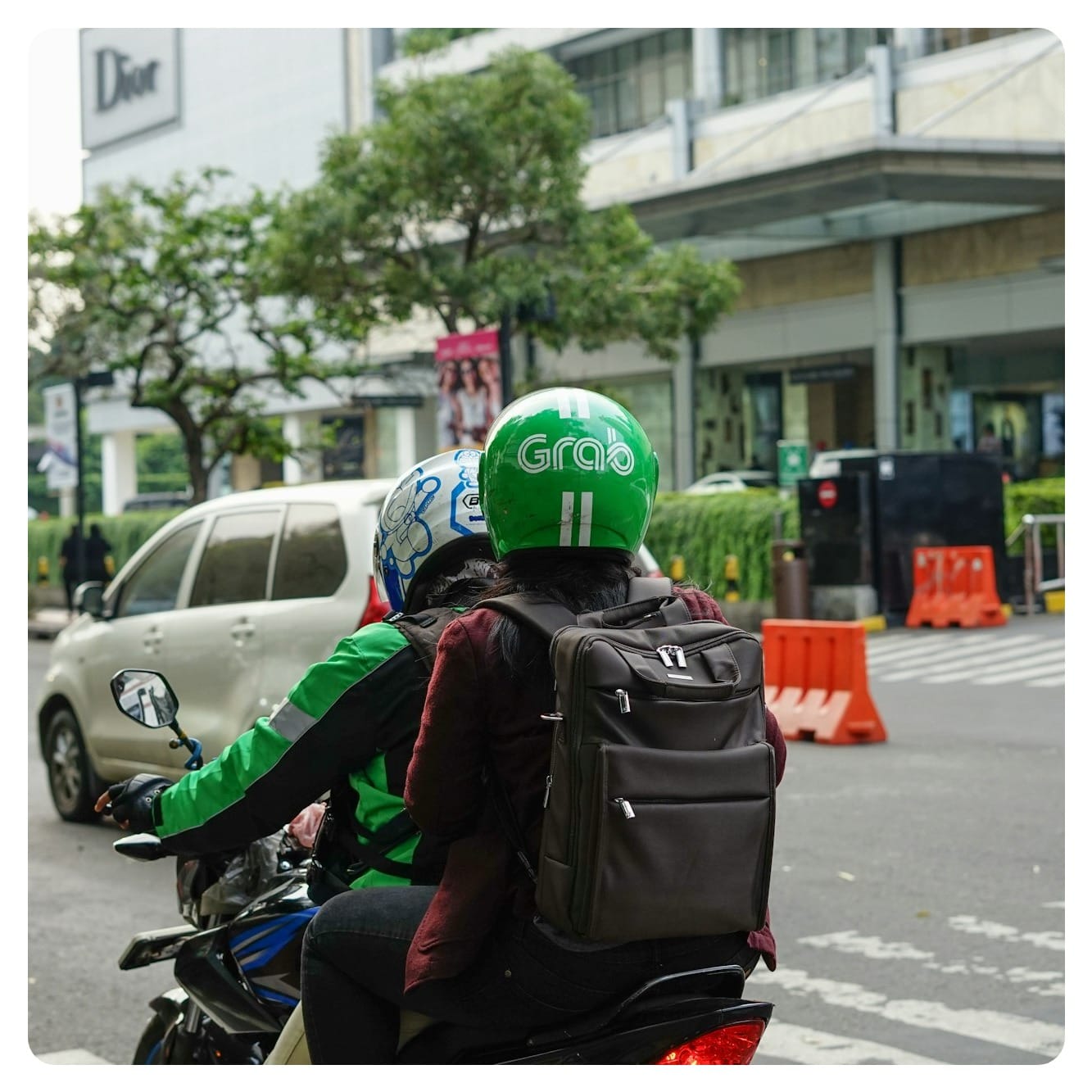 man riding Grab motorbike and carrying tourist passenger