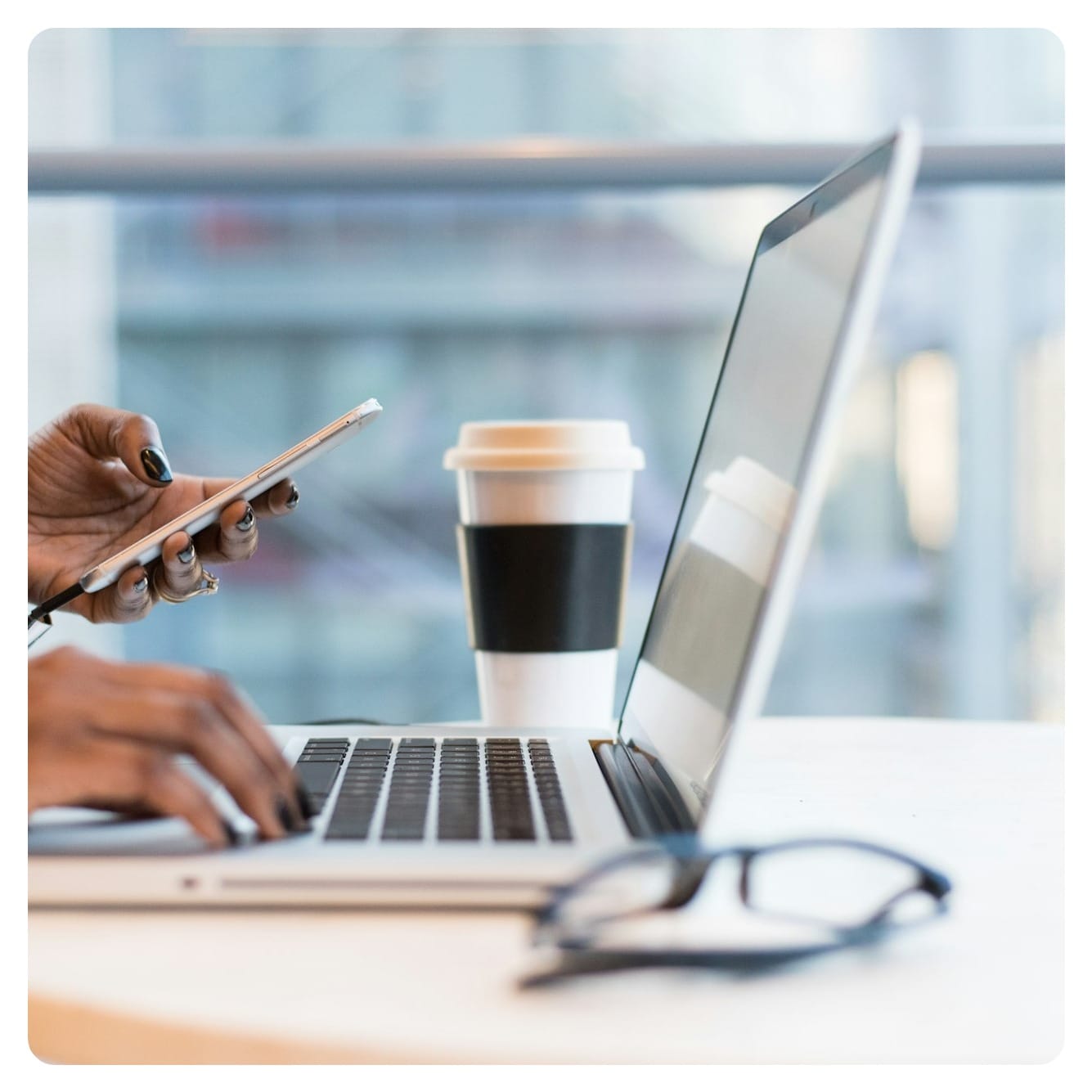 person using smartphone and MacBook